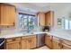 Well-lit kitchen featuring wooden cabinetry, quartz countertops, and stainless steel appliances at 6845 S Webster St # G, Littleton, CO 80128