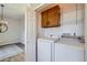 Functional laundry room featuring a washer, dryer, storage cabinets and utility shelving at 6845 S Webster St # G, Littleton, CO 80128