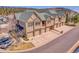 Aerial view of townhomes with attached garages, neutral paint, green trim and scenic mountain backdrop at 1194 Red Lodge Dr # 201, Evergreen, CO 80439
