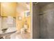 Bathroom features a sink, toilet, and a walk-in shower, with bright yellow walls and neutral floors at 2939 S Zurich Ct, Denver, CO 80236