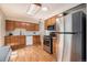 Well-maintained kitchen featuring stainless steel appliances, wooden cabinets, and hardwood floors at 2939 S Zurich Ct, Denver, CO 80236