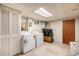 Convenient laundry room with washer, dryer, storage cabinets, and access to utility area at 2939 S Zurich Ct, Denver, CO 80236