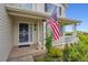 Inviting front porch with decorative details and an American flag, creating a warm and welcoming entrance at 5302 S Robb Ct, Littleton, CO 80127