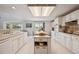 The kitchen has white cabinetry, an island, and modern appliances with tons of light at 5302 S Robb Ct, Littleton, CO 80127