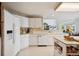 Bright kitchen features white cabinetry, modern appliances, and lots of natural light at 5302 S Robb Ct, Littleton, CO 80127