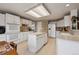 Updated kitchen boasts white cabinets, center island, and modern appliances with an accent wallpaper at 5302 S Robb Ct, Littleton, CO 80127