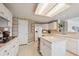 A kitchen with white cabinets, a large island, a built-in refrigerator and stainless steel sink at 5302 S Robb Ct, Littleton, CO 80127