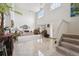 Bright living room with high ceilings, tile flooring, and a staircase leading to the upper level at 5302 S Robb Ct, Littleton, CO 80127