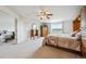 Spacious main bedroom featuring carpet, ceiling fan, armoire and an ensuite bath with window at 5302 S Robb Ct, Littleton, CO 80127