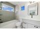 Modern bathroom featuring a tiled shower-bathtub, vanity and window at 2010 Irving St, Denver, CO 80211