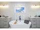 Bright bathroom showcasing a freestanding tub, dual sinks, and stylish lighting fixtures at 2010 Irving St, Denver, CO 80211