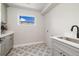 Well-lit laundry room featuring gray cabinets, a sink, and patterned flooring at 2010 Irving St, Denver, CO 80211