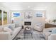 Bright living room with fireplace, neutral-toned furniture and windows with neighborhood views at 2010 Irving St, Denver, CO 80211