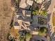 Bird's eye view of a spacious home featuring mature trees, large driveway, and outdoor fire pit at 5886 Amber Ridge Dr, Castle Pines, CO 80108