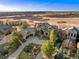 Stunning aerial view of a luxury home with a well-manicured landscape and a circular driveway at 5886 Amber Ridge Dr, Castle Pines, CO 80108