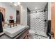Contemporary bathroom with a wood framed mirror and shower with patterned black and white tiles, and glass door at 5886 Amber Ridge Dr, Castle Pines, CO 80108