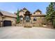 Stunning home with stone accents, beautiful landscaping, and a spacious driveway leading to an attached garage at 5886 Amber Ridge Dr, Castle Pines, CO 80108