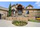 Stunning stone home showcasing manicured landscaping, a grand entrance, and excellent curb appeal at 5886 Amber Ridge Dr, Castle Pines, CO 80108