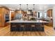 Beautiful kitchen featuring a large island with seating, stainless steel appliances, and wooden cabinets at 5886 Amber Ridge Dr, Castle Pines, CO 80108