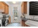 Well-appointed laundry room with wood cabinets, modern washer, and views of the backyard playset at 5886 Amber Ridge Dr, Castle Pines, CO 80108