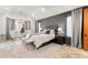 Bedroom with a large bed, sitting area, neutral colors, and a decorative chandelier at 5886 Amber Ridge Dr, Castle Pines, CO 80108
