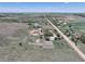 Aerial view showcasing a rural property with a home, outbuildings, and fenced pastures at 2091 Tate Ave, Fort Lupton, CO 80621