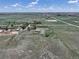 Wide aerial view of large property, including buildings, fenced horse areas, and access roads, showcasing the rural charm at 2091 Tate Ave, Fort Lupton, CO 80621