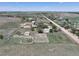 Wide aerial view of a rural property with a home, outbuildings, fenced areas, and spacious land at 2091 Tate Ave, Fort Lupton, CO 80621