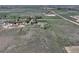 An aerial view of a farm property with a home, various outbuildings, and fenced pastures at 2091 Tate Ave, Fort Lupton, CO 80621