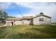Exterior view showcases well-maintained lawn, a small shed, and the rear facade of the home with a small brick patio at 2091 Tate Ave, Fort Lupton, CO 80621
