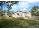 Backyard view shows lush greenery, a small storage shed, a wood fence, and a partial view of the home at 2091 Tate Ave, Fort Lupton, CO 80621