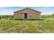 Tan barn with a sliding door on a grassy lot perfect for horses and other livestock at 2091 Tate Ave, Fort Lupton, CO 80621