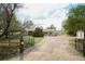 Charming ranch-style home with an open gate and a gravel driveway leading to a well-maintained yard at 2091 Tate Ave, Fort Lupton, CO 80621