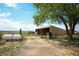 Open-air outbuilding with adjacent tank provides farm or ranch storage in rural setting at 2091 Tate Ave, Fort Lupton, CO 80621