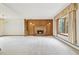 Bright living room featuring a fireplace, wood paneled wall and a large bay window at 8588 E Costilla Ave, Centennial, CO 80112