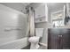 This bathroom features a tub with shower, toilet, and a dark vanity at 1341 Kingfisher Ave, Brighton, CO 80601