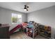 This room boasts a loft bed with a slide, a window, a ceiling fan, and is great for playtime at 1341 Kingfisher Ave, Brighton, CO 80601