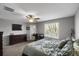 This bedroom features a ceiling fan, a TV, a window for natural light, and a desk area for work or study at 1341 Kingfisher Ave, Brighton, CO 80601