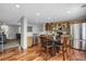 Bright eat-in kitchen featuring stainless steel appliances and rich hardwood floors at 1341 Kingfisher Ave, Brighton, CO 80601