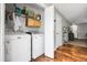 Updated laundry room with modern washer and dryer, cabinets, and wood floors at 1341 Kingfisher Ave, Brighton, CO 80601