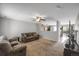 Open-concept living room with a cozy carpet and views into an adjacent kitchen at 1341 Kingfisher Ave, Brighton, CO 80601
