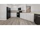 White kitchen cabinets, black appliances, and hardwood floors at 20514 E Girard Pl, Aurora, CO 80013