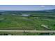 Panoramic aerial view displays serene lake and verdant fields, creating a peaceful, picturesque setting at 14191 W Amherst Ave, Lakewood, CO 80228
