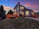 Dusk view of backyard showcasing deck, lush lawn, and well-lit exterior for evening enjoyment at 14191 W Amherst Ave, Lakewood, CO 80228