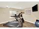 Basement featuring home gym with modern workout equipment and mounted television at 14191 W Amherst Ave, Lakewood, CO 80228