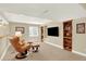 Finished basement offers a cozy seating area with bookshelves and a mounted TV for entertainment at 14191 W Amherst Ave, Lakewood, CO 80228