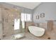 Luxurious bathroom featuring a walk-in shower and a freestanding soaking tub for relaxation at 14191 W Amherst Ave, Lakewood, CO 80228