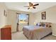Cozy bedroom features a ceiling fan, tan walls, neutral carpet, and large window with scenic outdoor views at 14191 W Amherst Ave, Lakewood, CO 80228