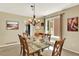 Formal dining room with a glass table and chairs illuminated by a chandelier at 14191 W Amherst Ave, Lakewood, CO 80228