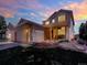 Charming two-story home with a well-manicured lawn and flower beds at twilight at 14191 W Amherst Ave, Lakewood, CO 80228